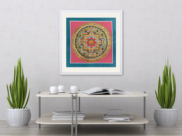 Hand-painted double vajra mandala in a white frame with a mat, above a table: a crossed vajra on a red lotus at the centre