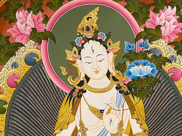 Close-up of a hand-painted White Tara thangka: her face, halo and raised hand in fine gold-coloured line work