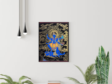 Hand-painted Kali thangka in black and gold, framed on a white wall: the blue goddess stands on Shiva