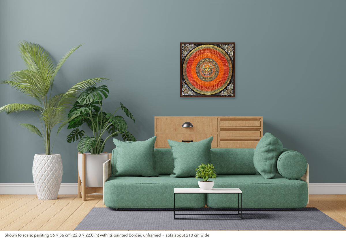 Jambhala Mantra Mandala thangka shown to scale in a living room, unframed, above a sofa about 210 cm wide (56×56 cm)