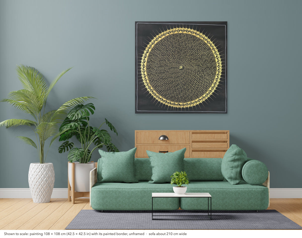 Mantra Mandala thangka shown to scale in a living room, unframed, above a sofa about 210 cm wide (108×108 cm)