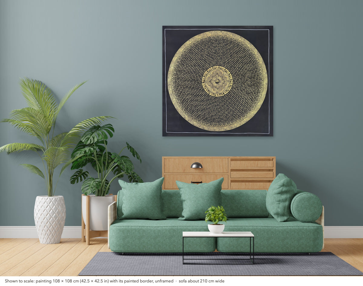 Mantra Mandala thangka shown to scale in a living room, unframed, above a sofa about 210 cm wide (108×108 cm)