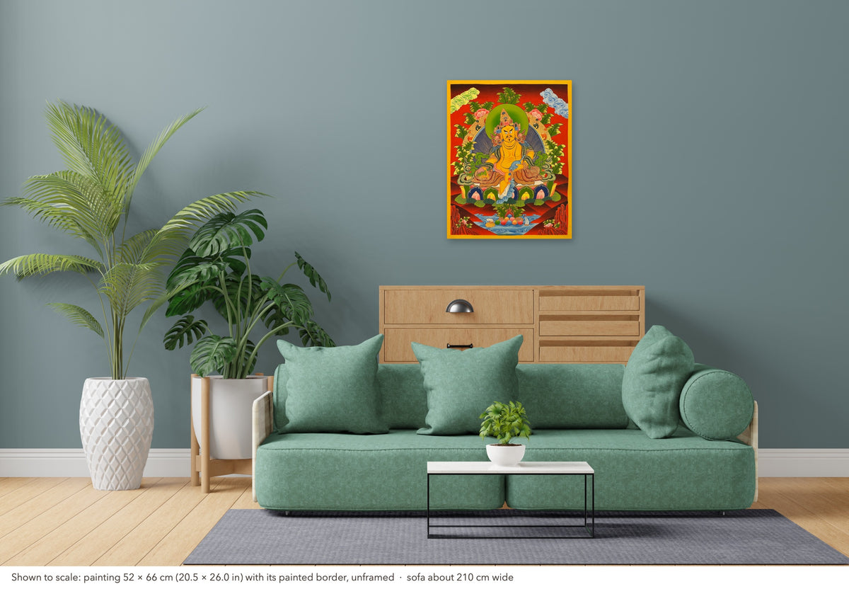 Jambhala thangka shown to scale in a living room, unframed, above a sofa about 210 cm wide (52×66 cm)