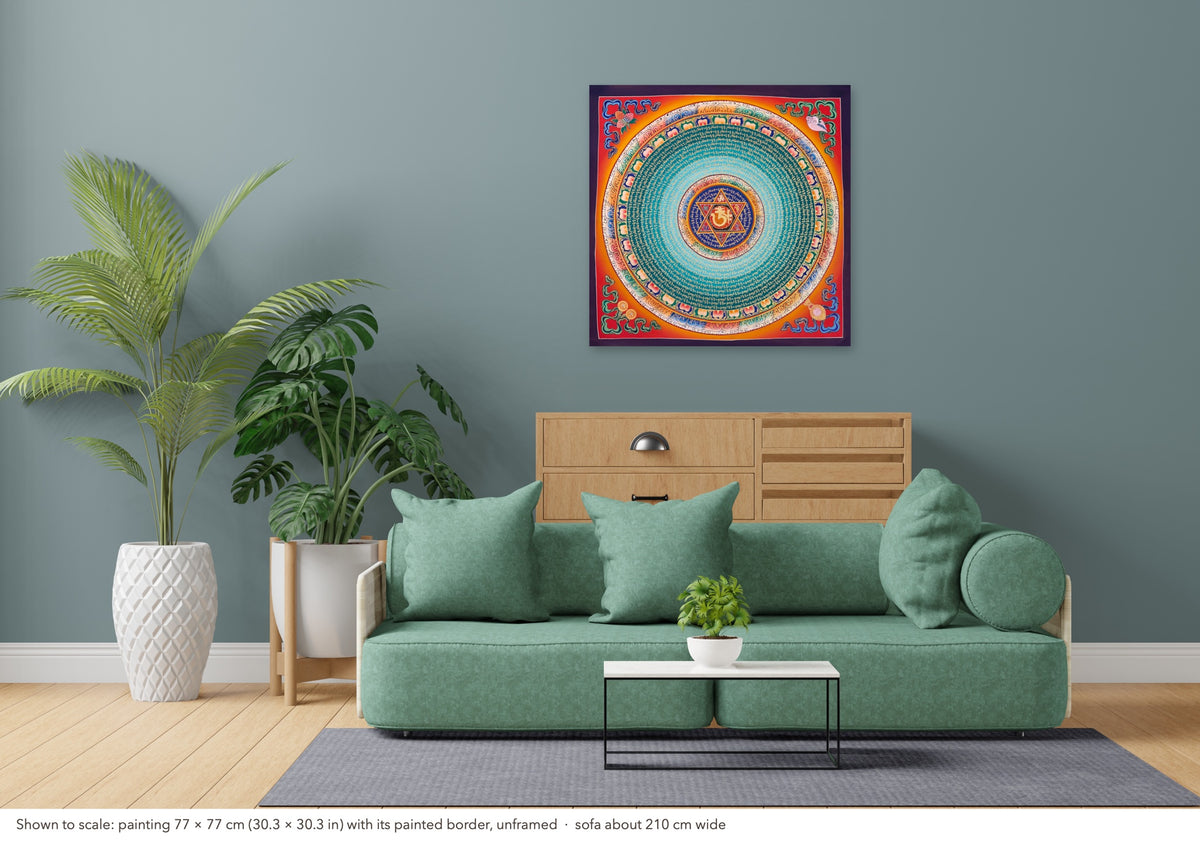 Mantra Mandala thangka shown to scale in a living room, unframed, above a sofa about 210 cm wide (77×77 cm)