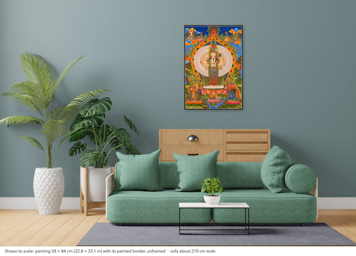 Thousand-armed Chenrezig thangka shown to scale in a living room, unframed, above a sofa about 210 cm wide (58×84 cm)