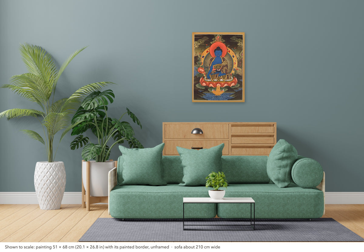 Medicine Buddha thangka shown to scale in a living room, unframed, above a sofa about 210 cm wide (51×68 cm)