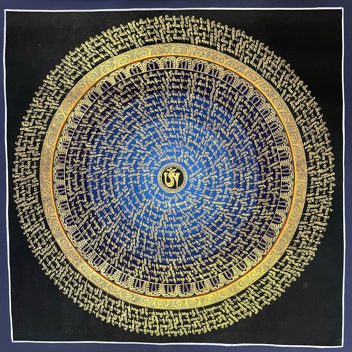 Mantra Mandala thangka, 75×75 cm: rings of gold-coloured mantra script on a blue disc around a central Om, with an outer ring of script on black