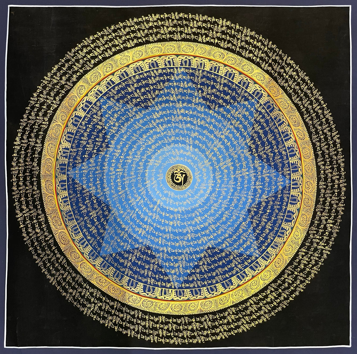 Mantra Mandala thangka, 75×75 cm: rings of gold-coloured mantra script on a blue disc around a central Om, with an outer ring of script on black