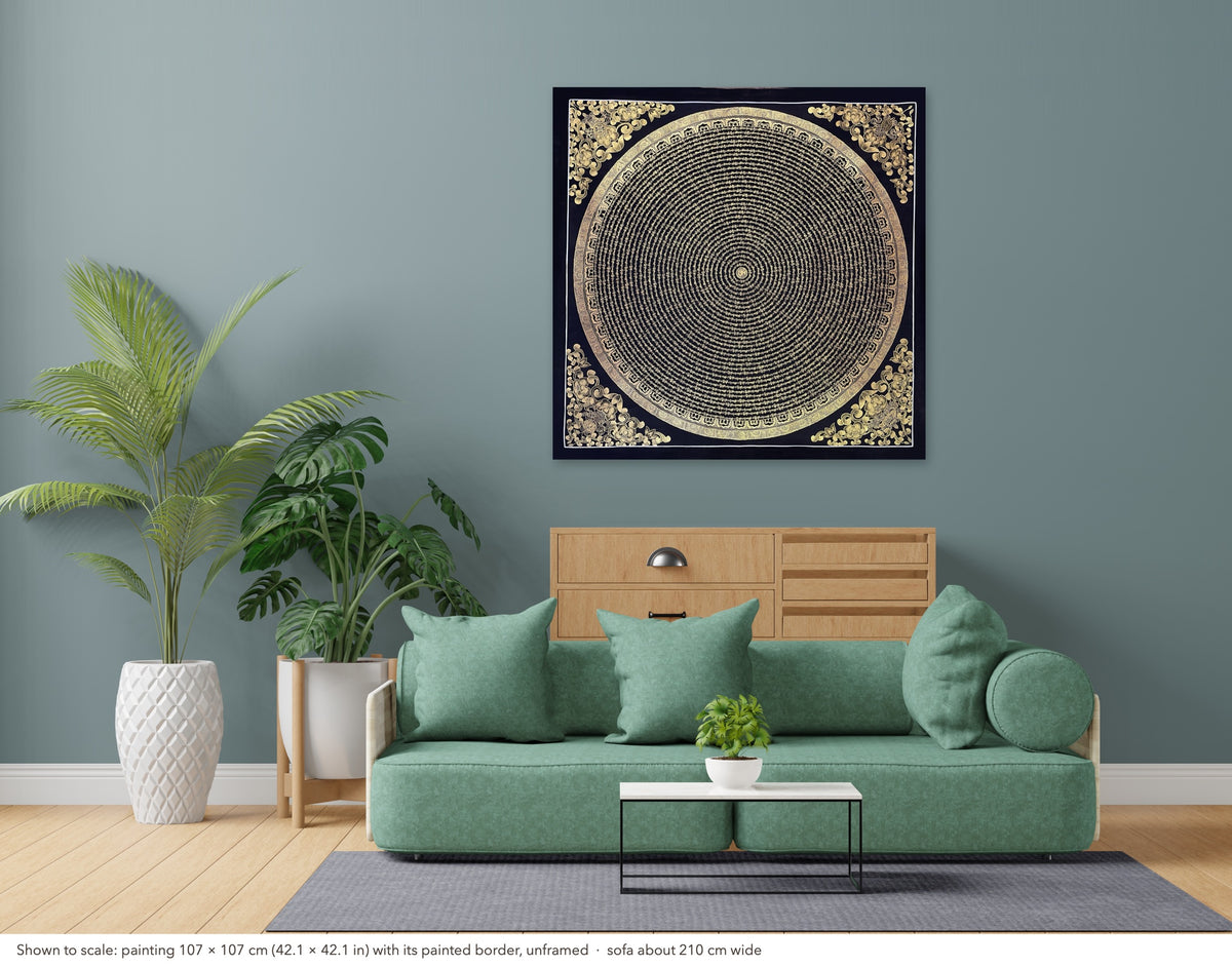 Mantra Mandala thangka shown to scale in a living room, unframed, above a sofa about 210 cm wide (107×107 cm)