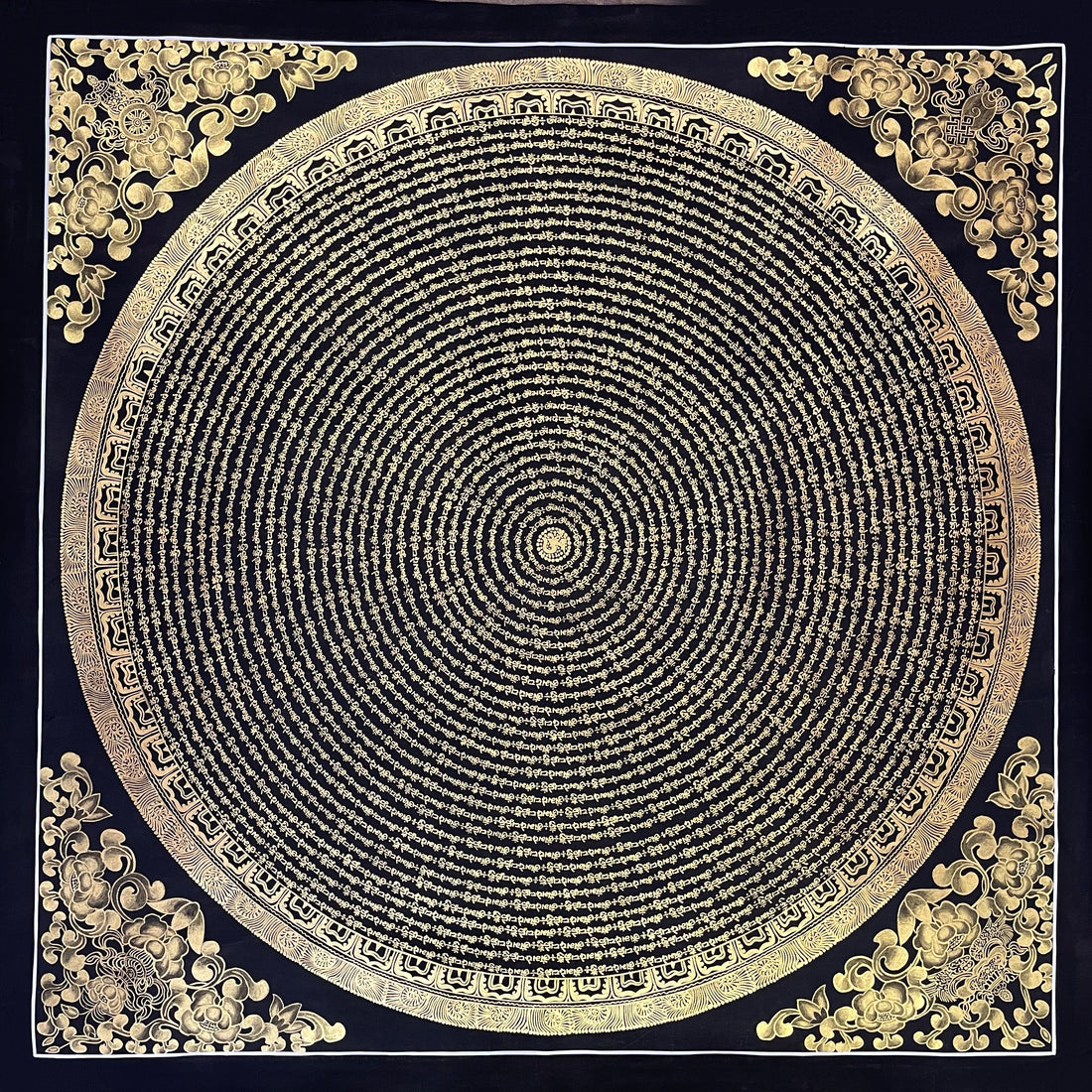 Mantra Mandala thangka, 107×107 cm: concentric rings of gold-coloured mantra script on black, with gold-coloured peonies in the corners