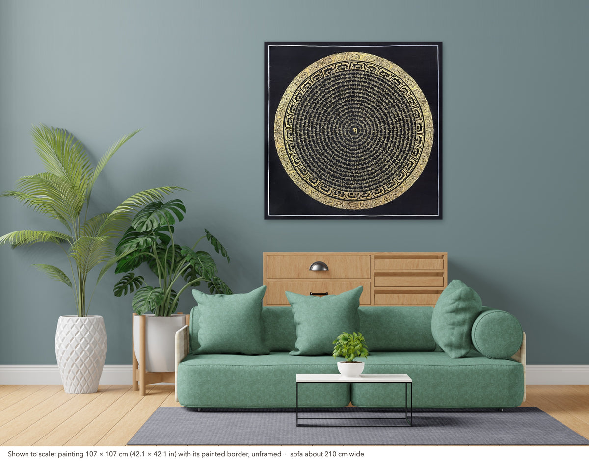 Mantra Mandala thangka shown to scale in a living room, unframed, above a sofa about 210 cm wide (107×107 cm)