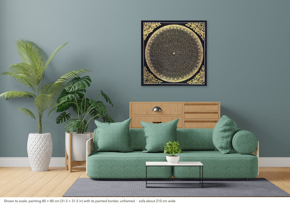 Mantra Mandala thangka shown to scale in a living room, unframed, above a sofa about 210 cm wide (80×80 cm)