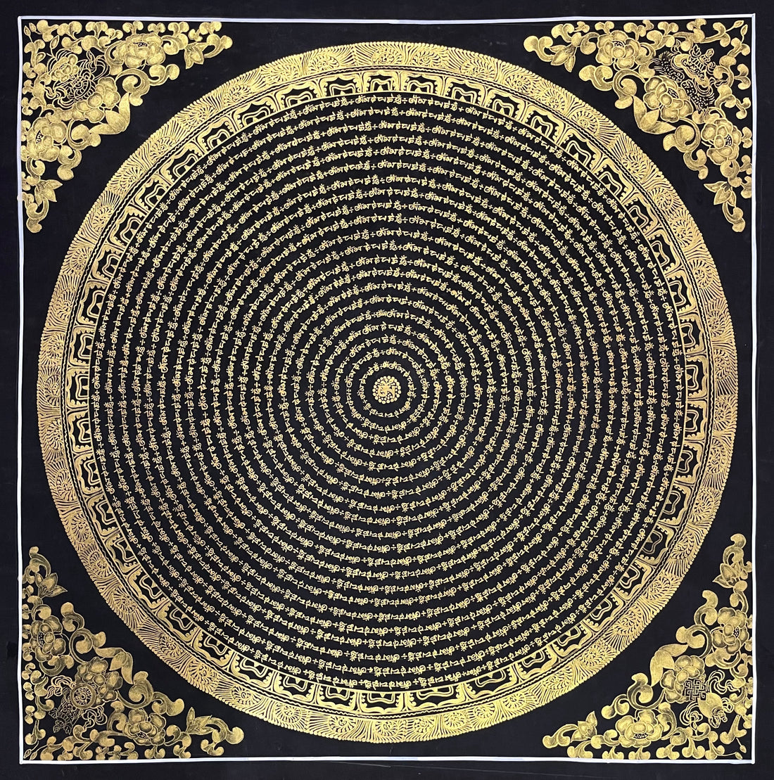 Mantra Mandala thangka, 80×80 cm: concentric rings of gold-coloured mantra script on black, with gold-coloured peonies in the corners