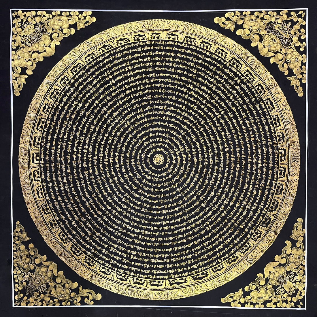 Mantra Mandala thangka, 80×80 cm: concentric rings of gold-coloured mantra script on black, with gold-coloured peonies in the corners