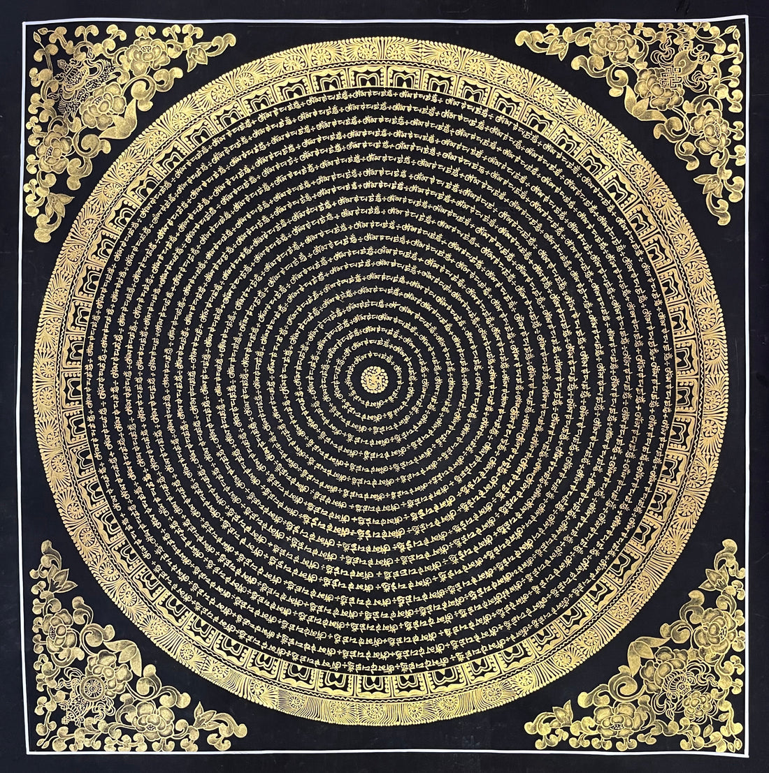 Mantra Mandala thangka, 80×80 cm: concentric rings of gold-coloured mantra script on black, with gold-coloured peonies in the corners