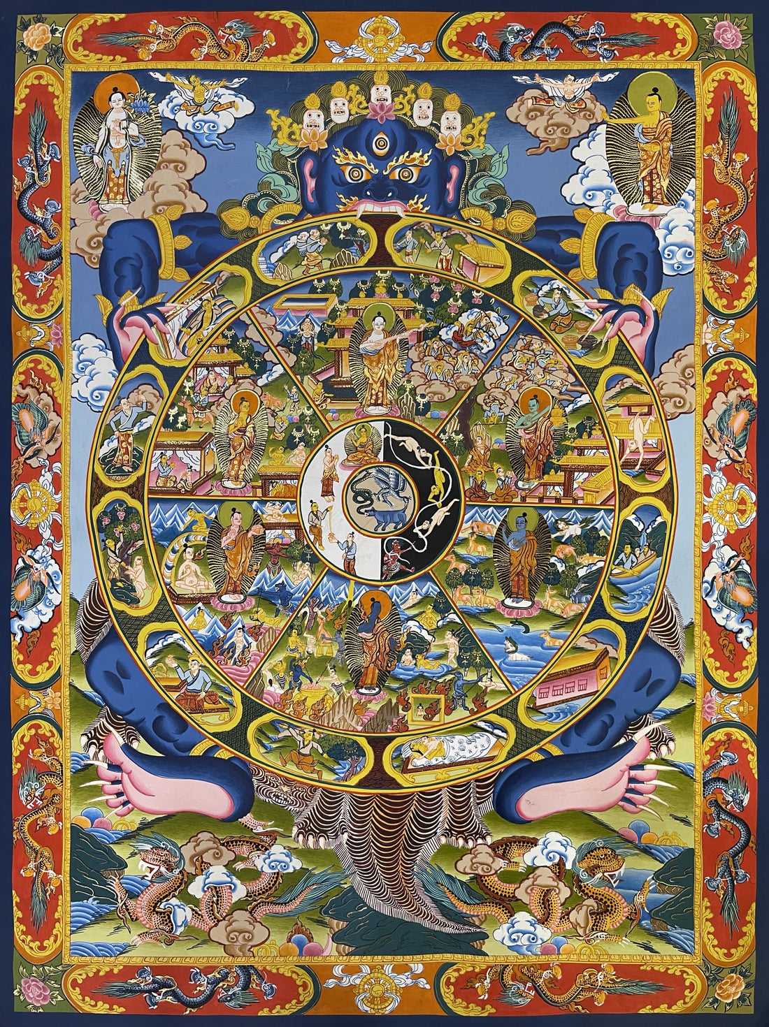 Wheel of Life thangka, 50×64 cm: blue Yama holding the Wheel of Life with a Buddha in each realm, inside a red border of dragons