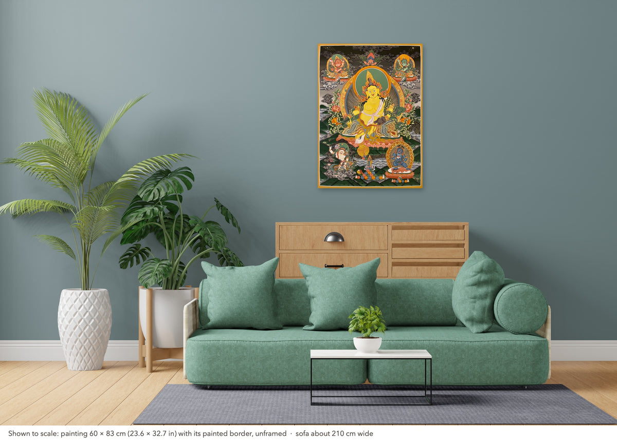 Jambhala thangka shown to scale in a living room, unframed, above a sofa about 210 cm wide (60×83 cm)