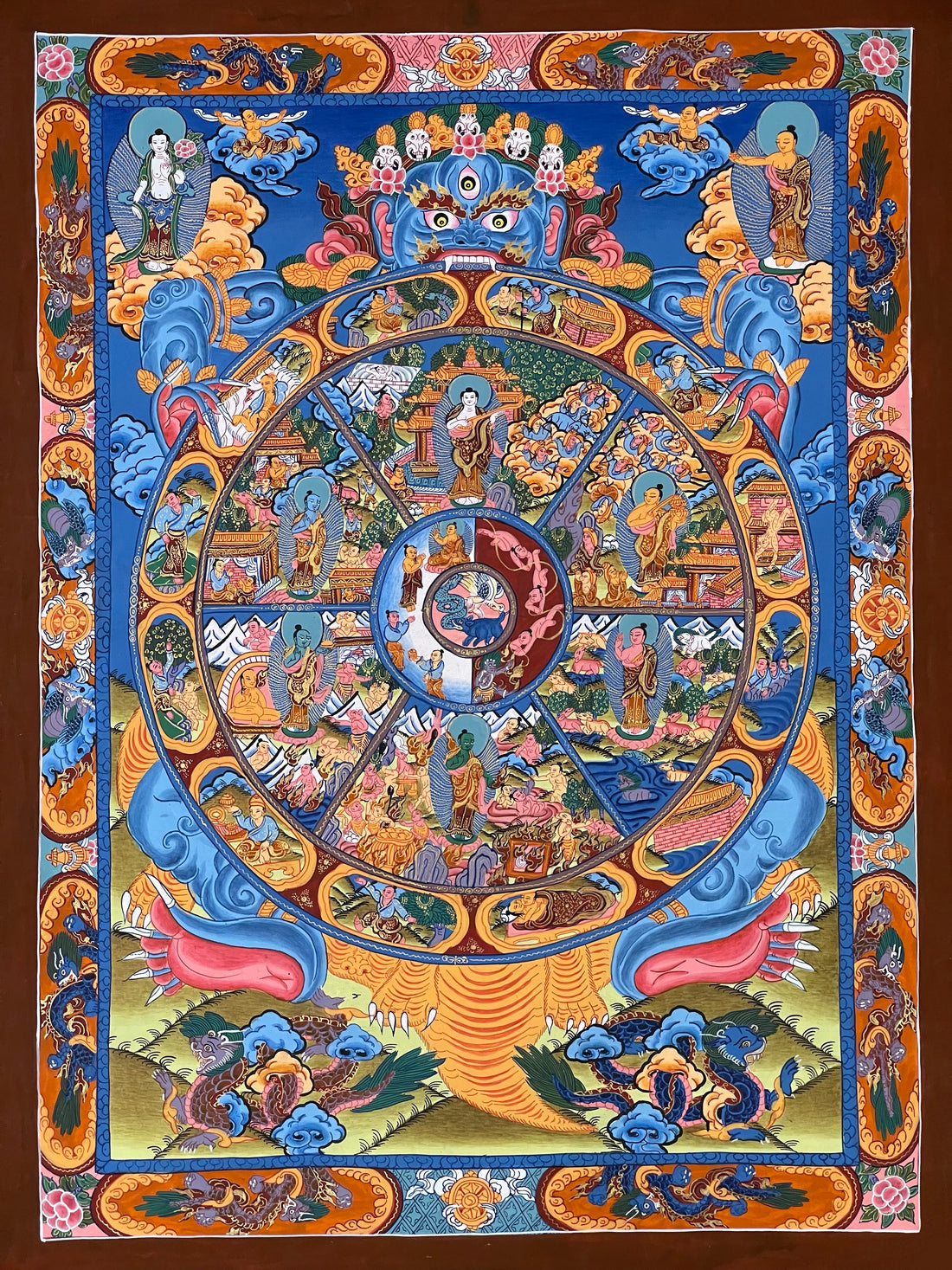 Wheel of Life thangka, 45×60 cm: blue Yama holding the Wheel of Life on deep blue, framed by an orange border of dragons