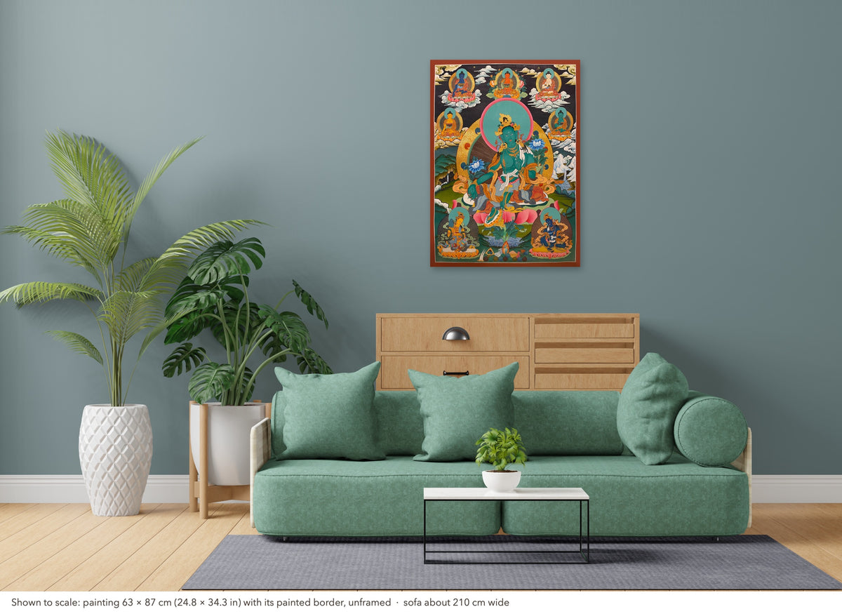 Green Tara thangka shown to scale in a living room, unframed, above a sofa about 210 cm wide (63×87 cm)