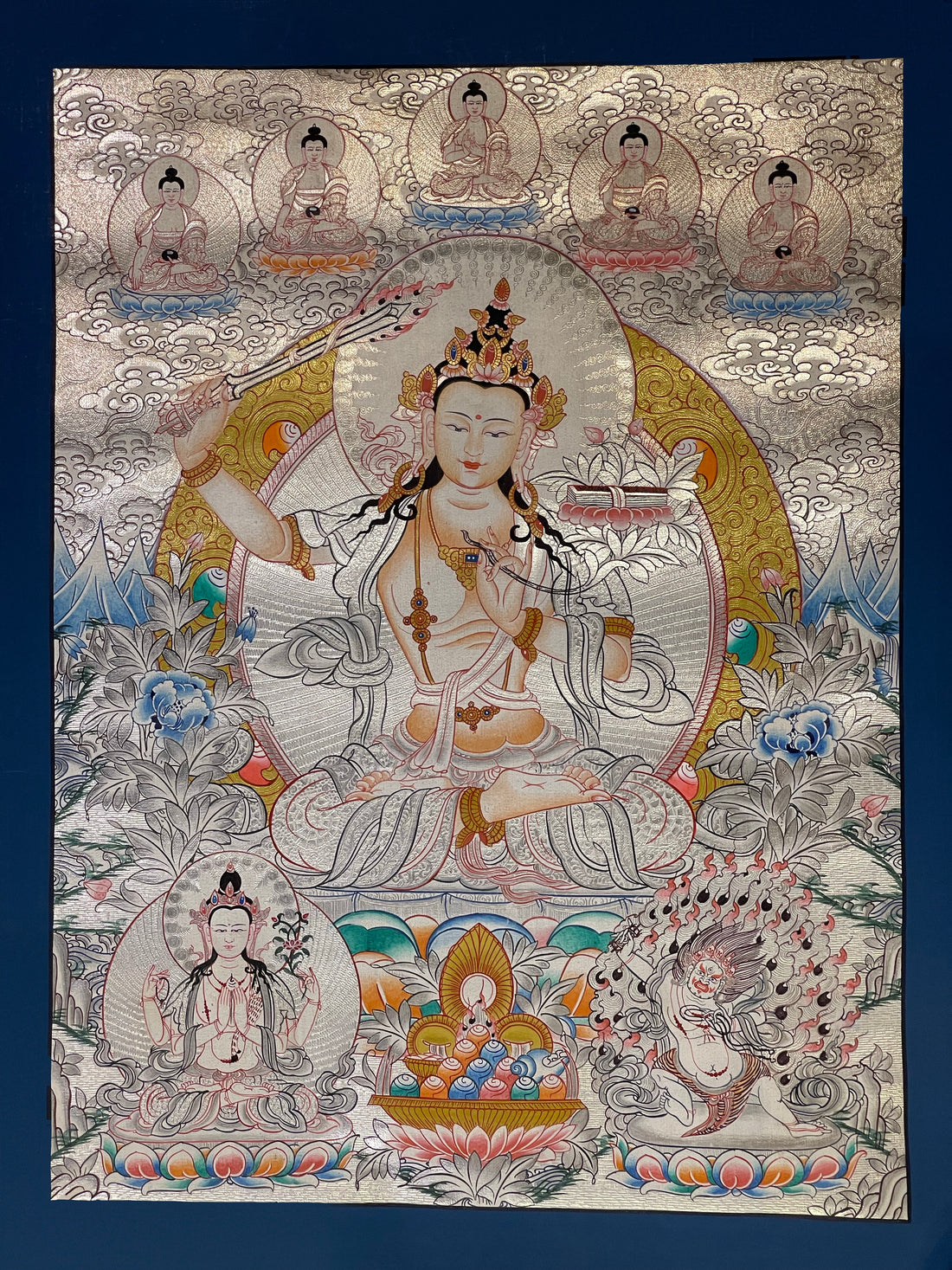 Manjushri thangka, 38×49 cm: Manjushri raising his sword in a pale silver-coloured palette, with the five Buddhas above