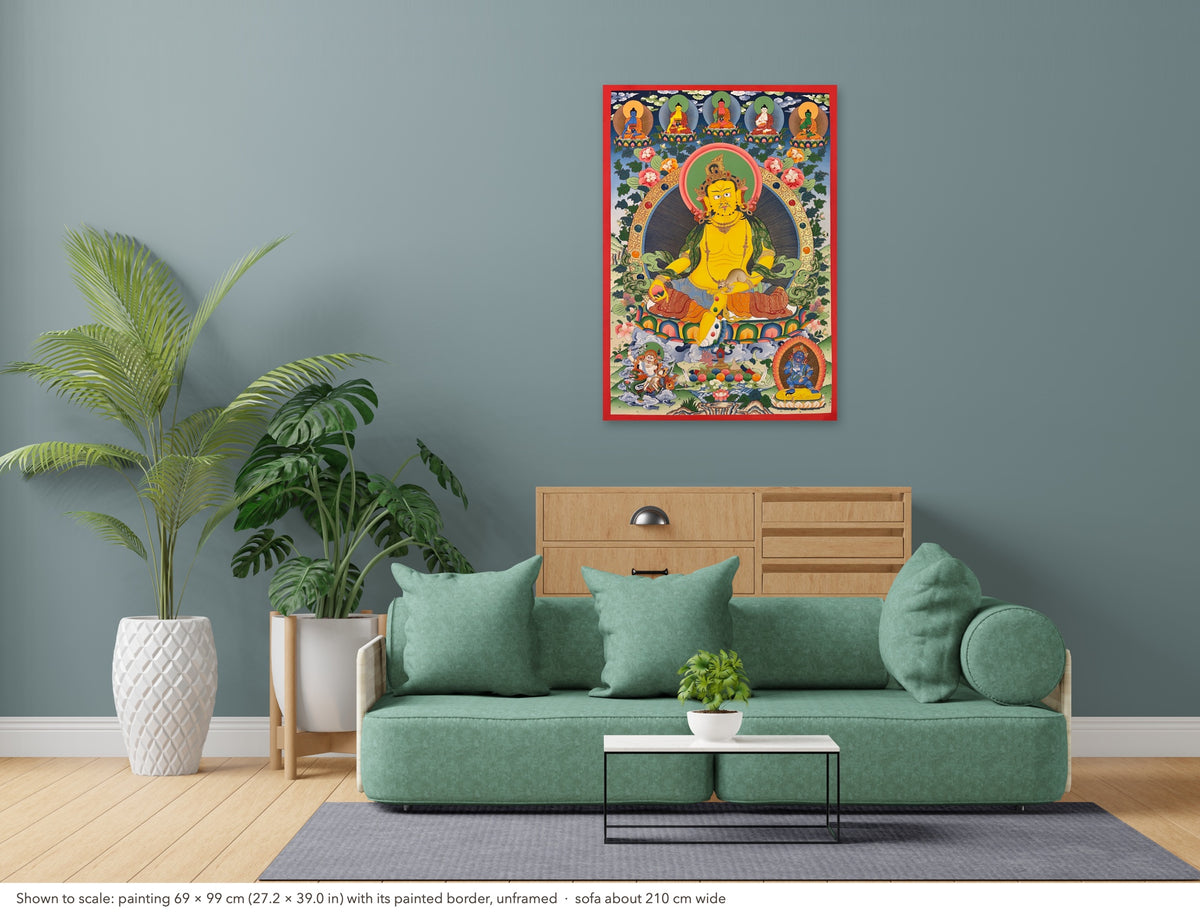 Jambhala thangka shown to scale in a living room, unframed, above a sofa about 210 cm wide (69×99 cm)