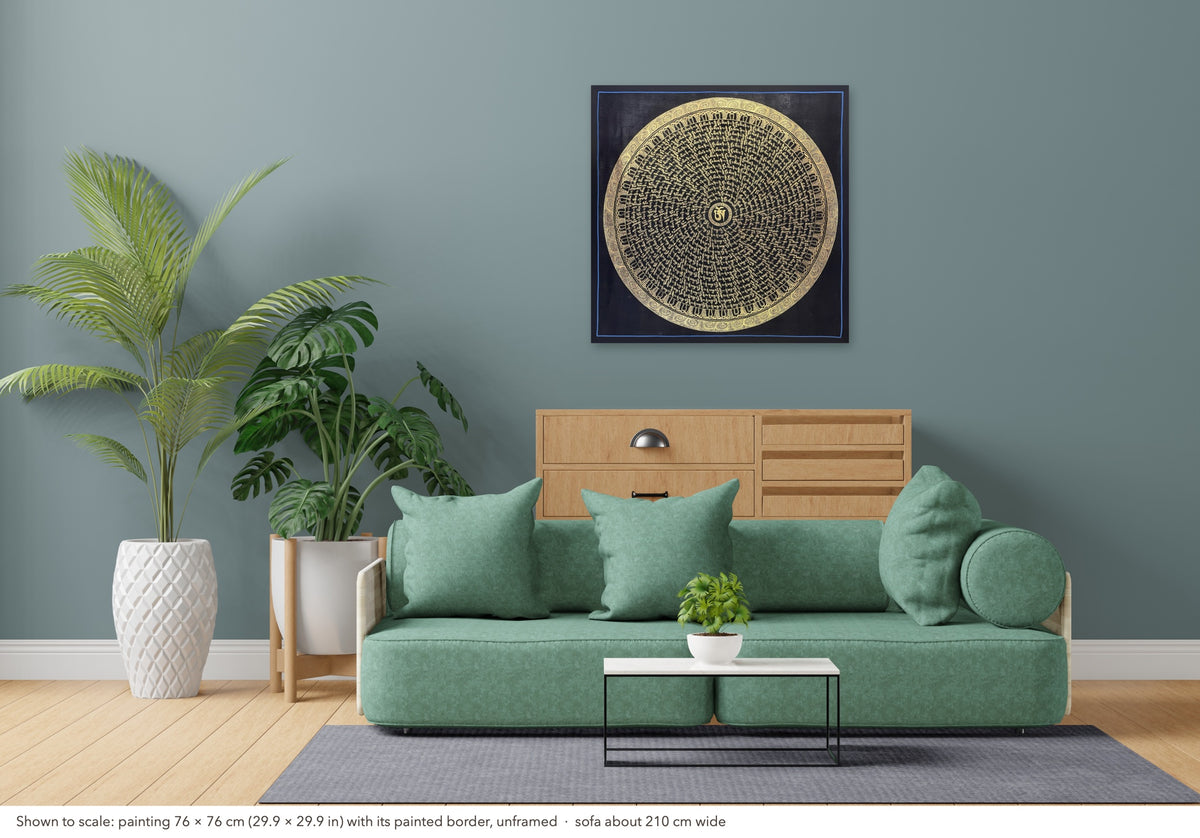 Mantra Mandala thangka shown to scale in a living room, unframed, above a sofa about 210 cm wide (76×76 cm)