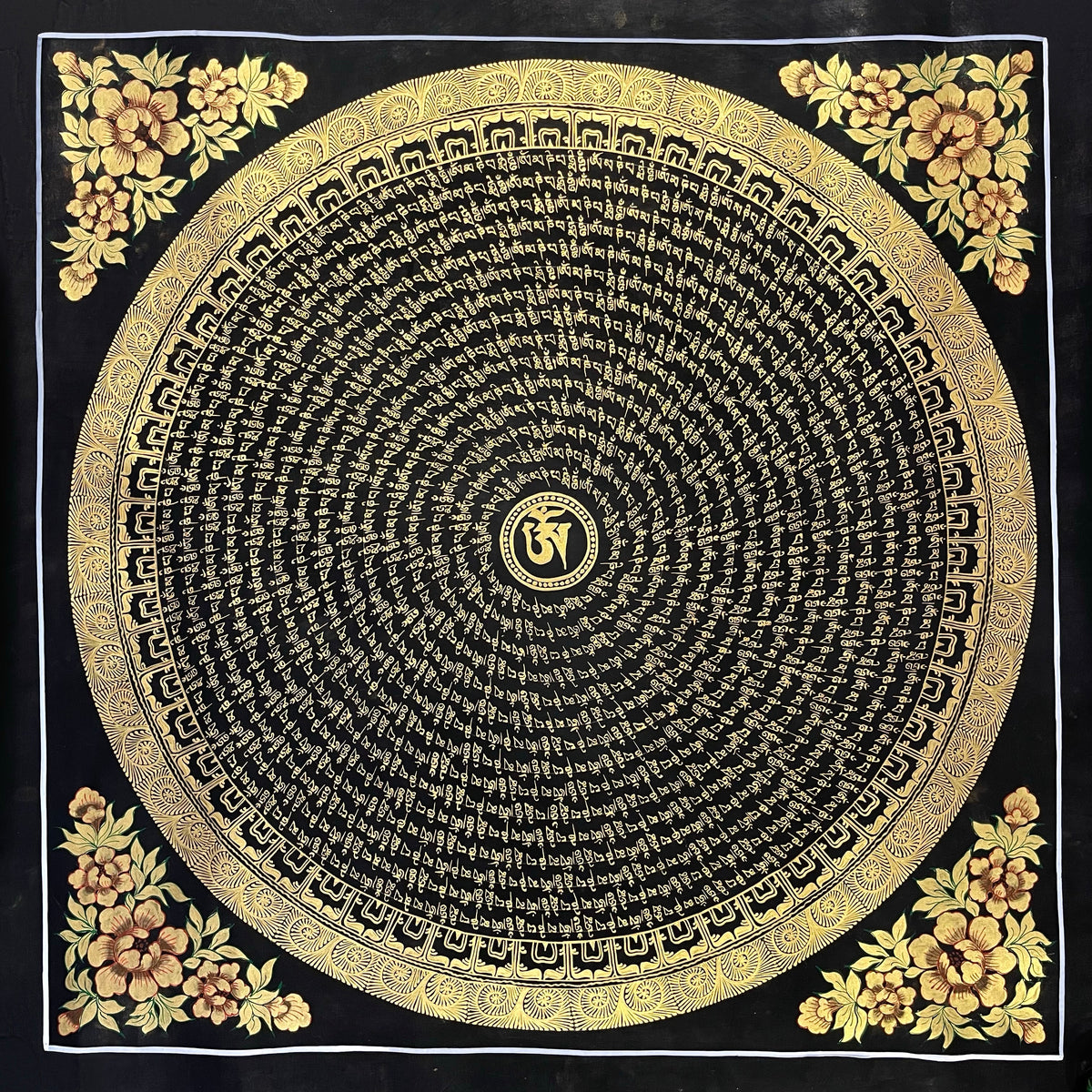 Mantra Mandala thangka, 76×76 cm: a spiral of gold-coloured mantra script on black around a central Om, with gold-coloured peonies in the corners