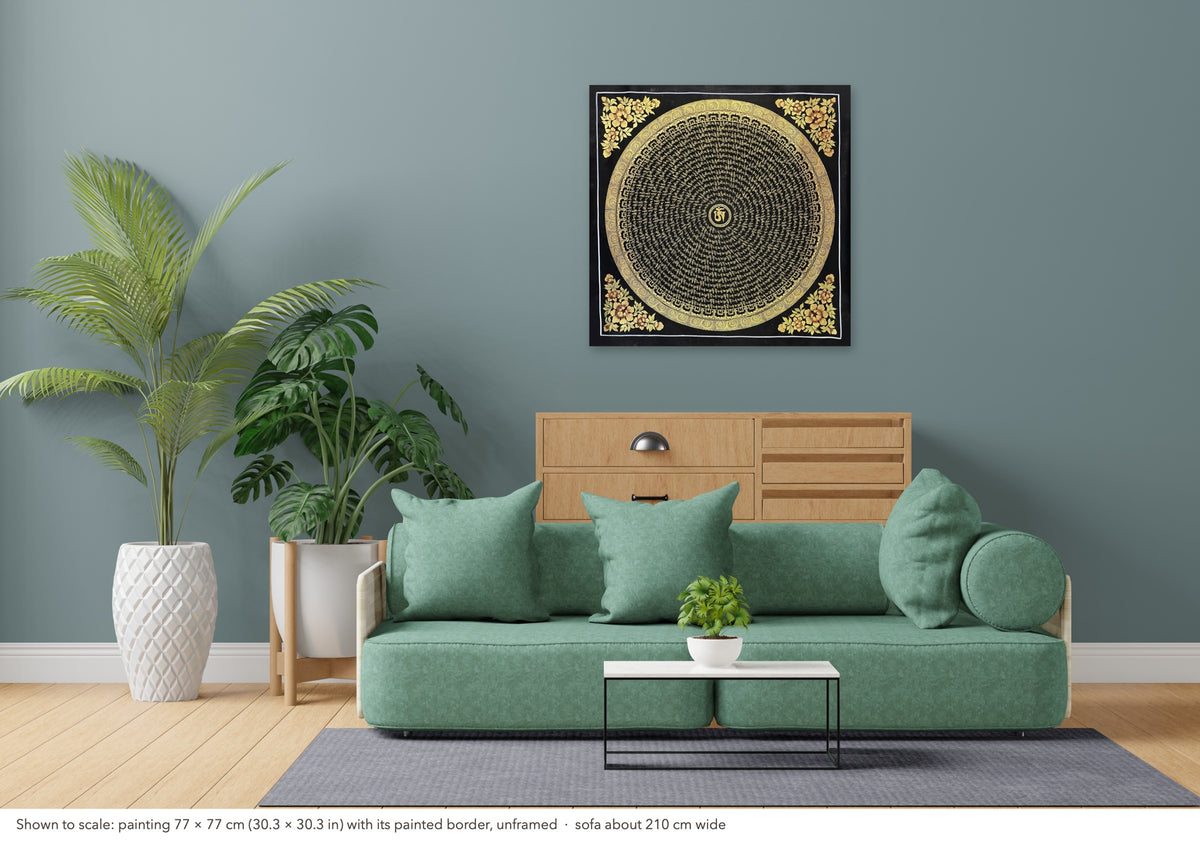 Mantra Mandala thangka shown to scale in a living room, unframed, above a sofa about 210 cm wide (77×77 cm)