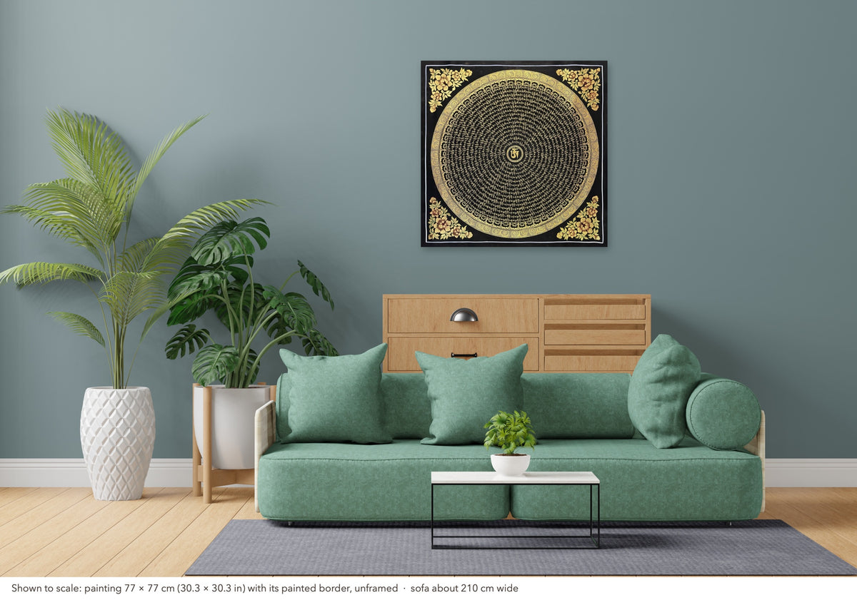 Mantra Mandala thangka shown to scale in a living room, unframed, above a sofa about 210 cm wide (77×77 cm)